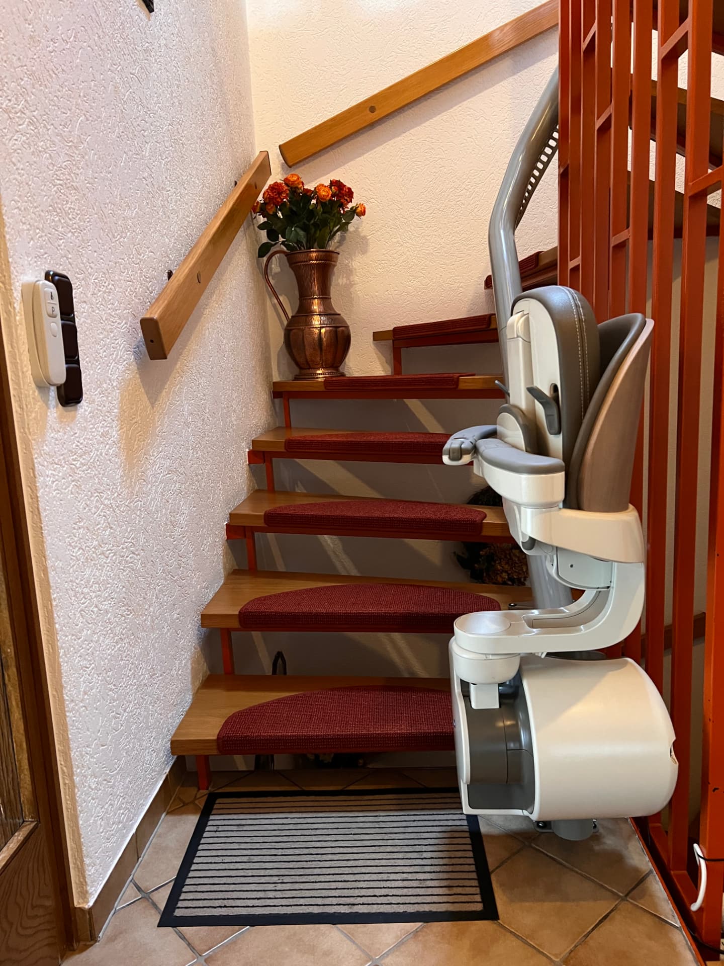 Untere Haltestelle eines Treppenlifts mit Funksender an der Wand
