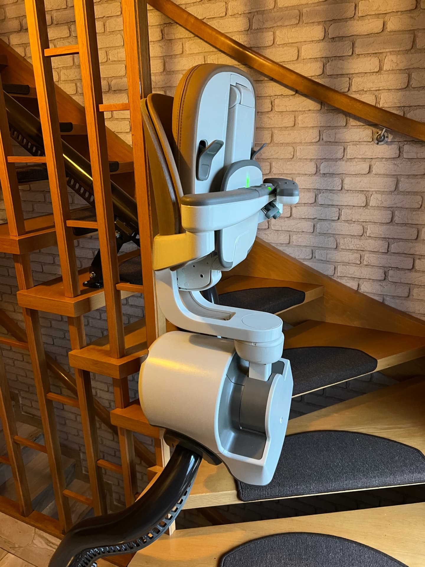 Treppenlift mit hochgeklapptem Sitz und Fußstütze an einer Innentreppe