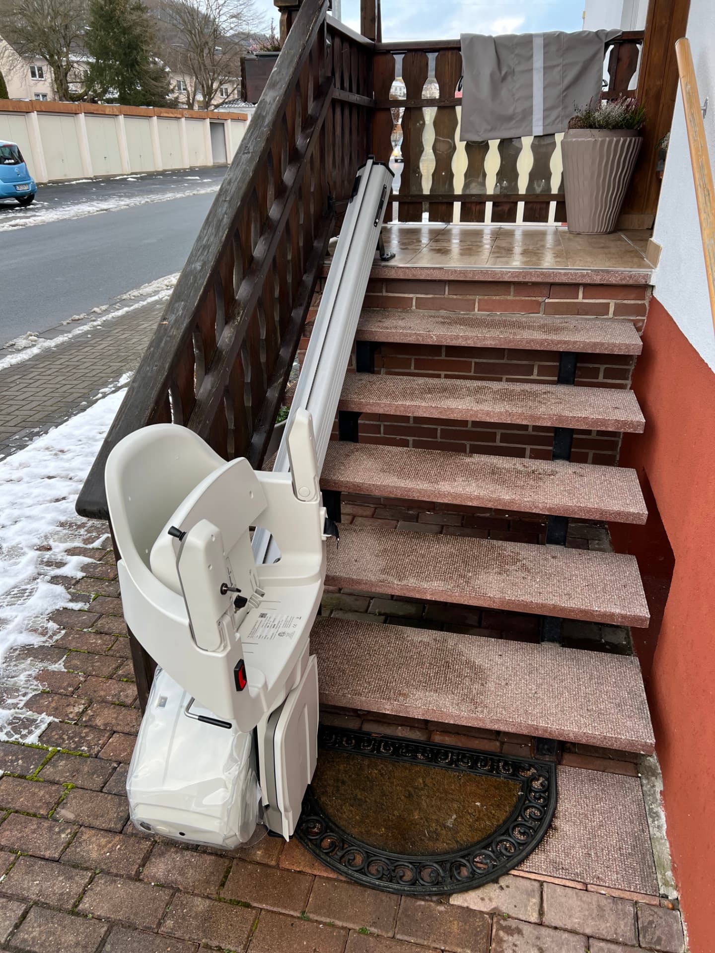 Außentreppenlift an einer Eingangstreppe bei Schnee mit Wetterschutzhaube